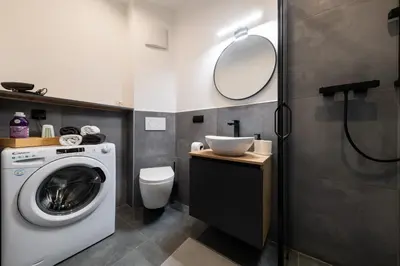 a bathroom with a washing machine and a sink at Belgrade Apartment Nook in Belgrade