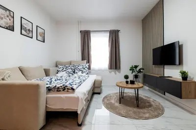 a living room with a couch and a tv at Belgrade Apartment Nook in Belgrade