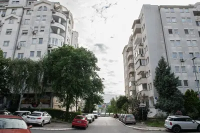 a city street with cars parked next to tall buildings at Belgrade Apartment Nook in Belgrade