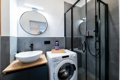 a bathroom with a washing machine and a mirror at Belgrade Apartment Nook in Belgrade