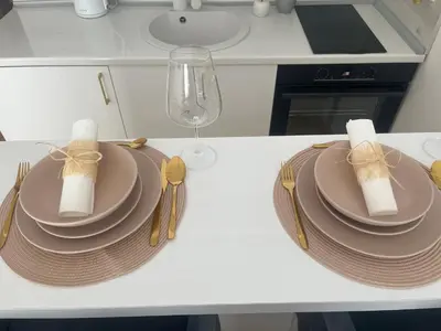 a table with plates and napkins and a wine glass at Maja lux in Ruma