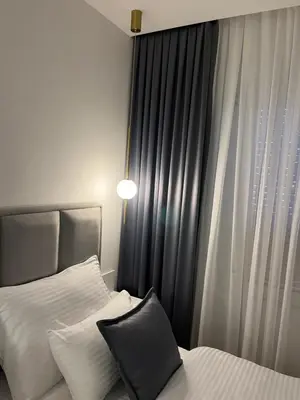 a bedroom with two beds and a window at Maja lux in Ruma