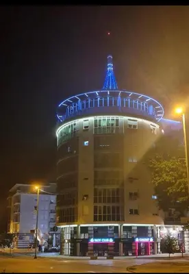 a building with a blue light on top at night at Maja lux in Ruma