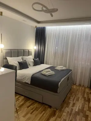a bedroom with a large bed and a window at Maja lux in Ruma