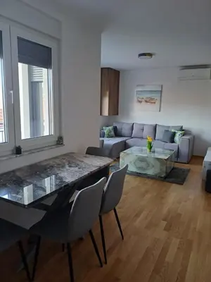 a living room with a table and a couch at Apartman ARISTEA in Arandjelovac
