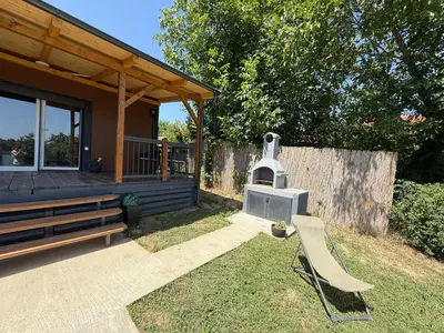 a house with a wood stove in the yard at Tiny house Neny Fruška gora in Velika Remeta