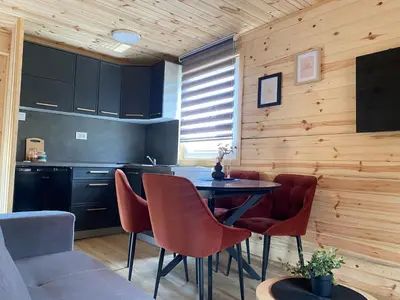 a kitchen with a table and chairs in a room at Tiny house Neny Fruška gora in Velika Remeta