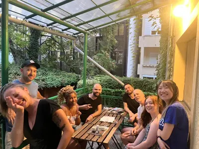 a group of people sitting around a picnic table at Hidden Gem Hostel in Belgrade