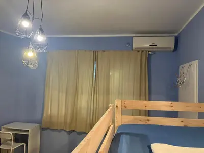 a bedroom with a wooden bed with blue walls at Hidden Gem Hostel in Belgrade