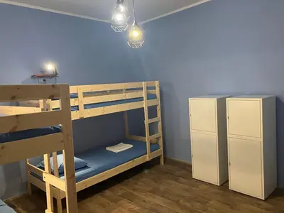 a bunk bed room with two bunk beds and a refrigerator at Hidden Gem Hostel in Belgrade