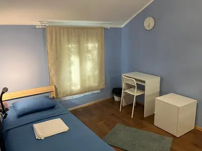 a bedroom with a bed and a desk and a window at Hidden Gem Hostel in Belgrade