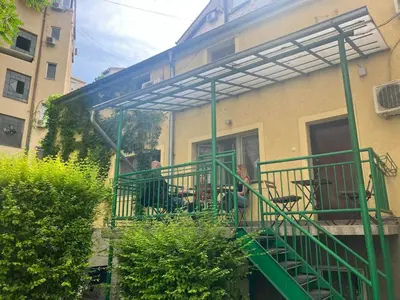 two people sitting on a balcony of a building at Hidden Gem Hostel in Belgrade