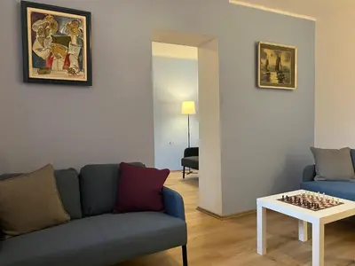 a living room with a couch and chessboard on a table at Hidden Gem Hostel in Belgrade