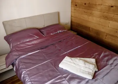 a bed with purple sheets and a pillow on it at Brvnara Staničić in Arandjelovac
