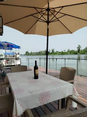 a bottle of wine sitting on a table with an umbrella at Splav na dan AXA in Barič