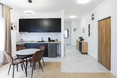 a kitchen with a table and chairs in a room at Airport Belgrade Apartments in Surčin