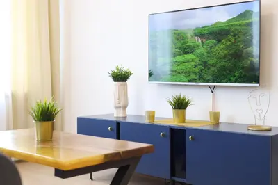 a living room with a tv on a blue cabinet at Airport Belgrade Apartments in Surčin