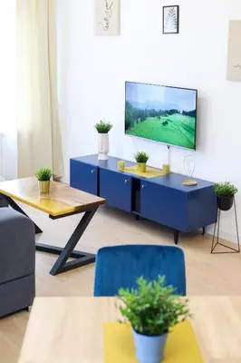a living room with a tv on a blue cabinet at Airport Belgrade Apartments in Surčin