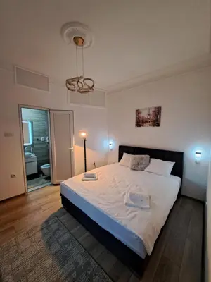 a bedroom with a large bed and a bathroom at Xena in Belgrade