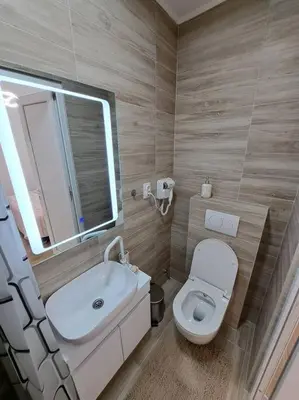 a bathroom with a toilet and a sink and a mirror at Xena in Belgrade