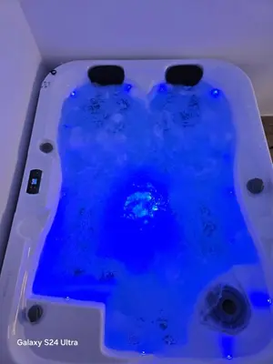 a tub filled with blue water in a room at IDILA SPA New Belgrade in Novi Beograd