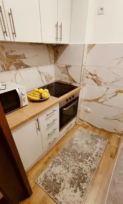 a kitchen with white cabinets and a plate of fruit at Medison in Belgrade
