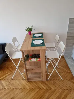 a wooden table and chairs in a room at Jela in Belgrade