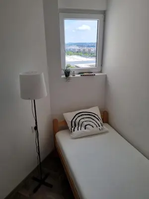 a small bedroom with a bed and a window at Jela in Belgrade