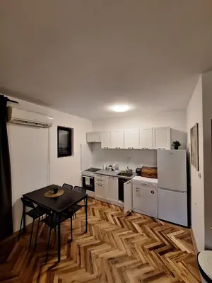 a kitchen with a table and a kitchen with white appliances at Kosmajski Beg: Vaša privatna vikendica sa bazenom in Nemenikuće