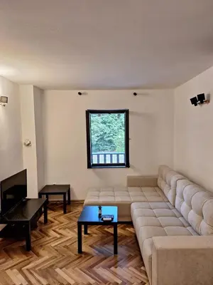 a living room with a couch and a table at Kosmajski Beg: Vaša privatna vikendica sa bazenom in Nemenikuće