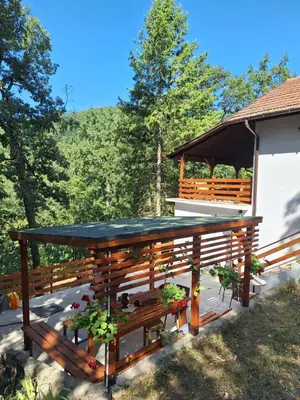a wooden deck with a gazebo with plants at Šumska Kosmaj in Nemenikuće