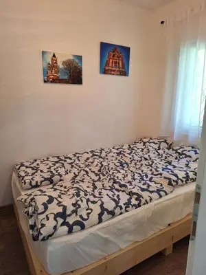 a bed in a bedroom with three pictures on the wall at Šumska Kosmaj in Nemenikuće