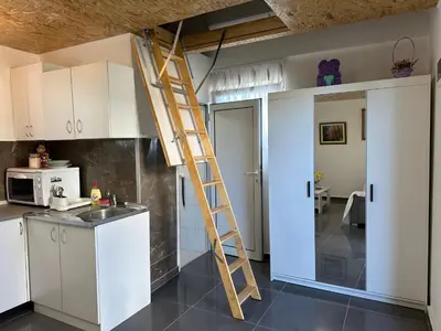 a ladder in a kitchen next to a kitchen at Apartman Aerodrom in Surčin