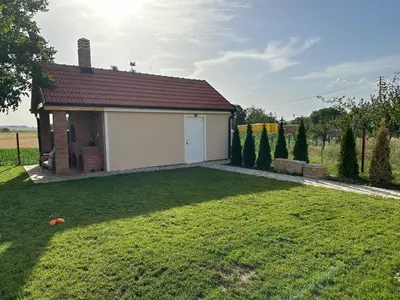 a small house with a garage in a yard at Apartman Aerodrom in Surčin
