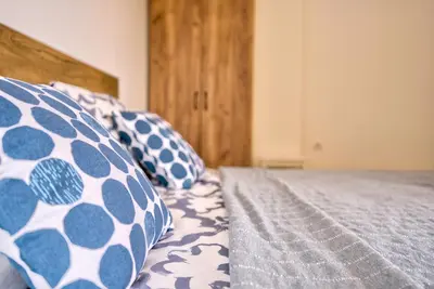a bed with blue and white pillows on it at Vračar Central Apartment in Belgrade