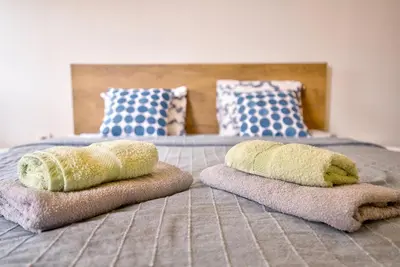 a bed with towels and pillows on it at Vračar Central Apartment in Belgrade