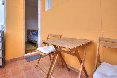 a wooden table and two chairs in a room at Vračar Central Apartment in Belgrade