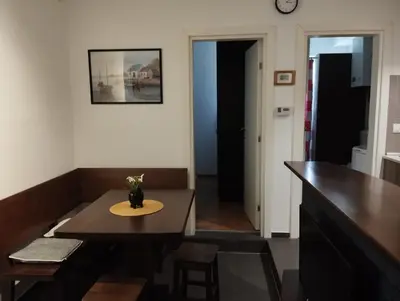 a room with a table and a kitchen with a counter at Apartman Nera in Stara Pazova