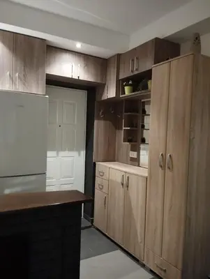 a kitchen with wooden cabinets and a white refrigerator at Apartman Nera in Stara Pazova