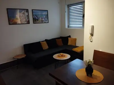 a living room with a black couch and a table at Apartman Nera in Stara Pazova