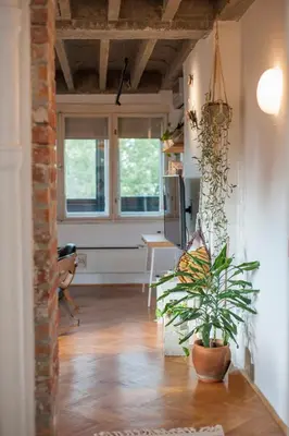 a living room with a potted plant on the floor at URBAN GREEN Corner with a Story in Belgrade
