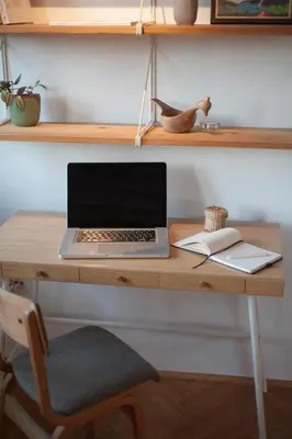 a laptop computer sitting on top of a wooden desk at URBAN GREEN Corner with a Story in Belgrade