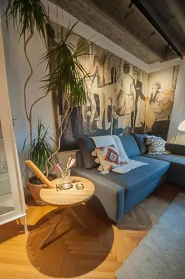 a bedroom with a blue bed and a table at URBAN GREEN Corner with a Story in Belgrade