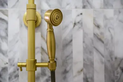 a gold shower head with a hose in front of a wall at URBAN DOWNTOWN luxury center Belgrade in Belgrade