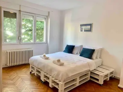 a bedroom with a large white bed with blue pillows at Belgrade Star with Free parking in Belgrade
