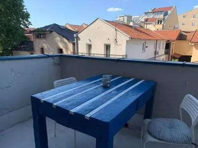 a blue wooden table on a balcony with chairs at Belgrade Star with Free parking in Belgrade
