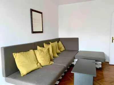 a gray couch with yellow pillows in a room at Belgrade Star with Free parking in Belgrade