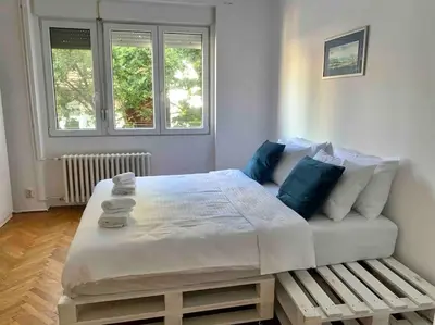 a bedroom with a large bed and a bench at Belgrade Star with Free parking in Belgrade