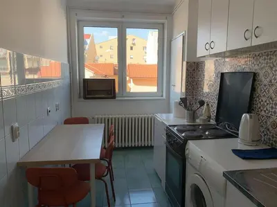 a kitchen with a stove and a table and a window at Belgrade Star with Free parking in Belgrade