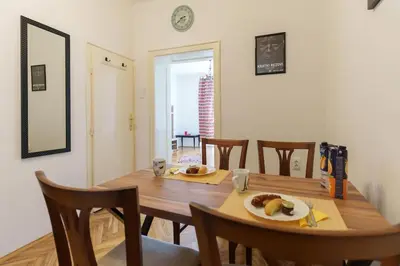 a dining room with a wooden table and chairs at Budislav lovely apartment in Belgrade